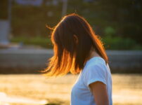 夕暮れの光に髪がやわらかく透ける女性の横顔｜懐かしい情景が静かによみがえる、やさしい記憶のイメージ写真