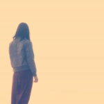 淡い光の中で静かに佇む女性の後ろ姿の情景|懐かしい情景が静かによみがえる、やさしい記憶のイメージ写真