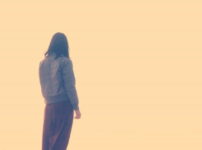 淡い光の中で静かに佇む女性の後ろ姿の情景｜懐かしい情景が静かによみがえる、やさしい記憶のイメージ写真