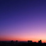夕暮れに染まる都会の空とビルのシルエットが静かに浮かぶ情景｜懐かしい情景が静かによみがえる、やさしい記憶のイメージ写真
