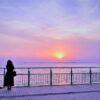 夕暮れの水辺で静かに佇む女性の後ろ姿｜懐かしい情景が静かによみがえる、やさしい記憶のイメージ写真