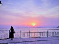 夕暮れの水辺で静かに佇む女性の後ろ姿｜懐かしい情景が静かによみがえる、やさしい記憶のイメージ写真