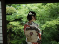 夕暮れの庭先で、浴衣姿の女性がそっと外を見つめる後ろ姿の情景｜懐かしい情景が静かによみがえる、やさしい記憶のイメージ写真
