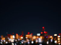 都会の夜に滲む暖色の灯りがぼんやりと揺れる情景｜懐かしい情景が静かによみがえる、やさしい記憶のイメージ写真