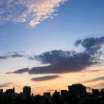 夕暮れの都会に静かに沈む光とビルのシルエットが映る風景｜懐かしい情景が静かによみがえる、やさしい記憶のイメージ写真